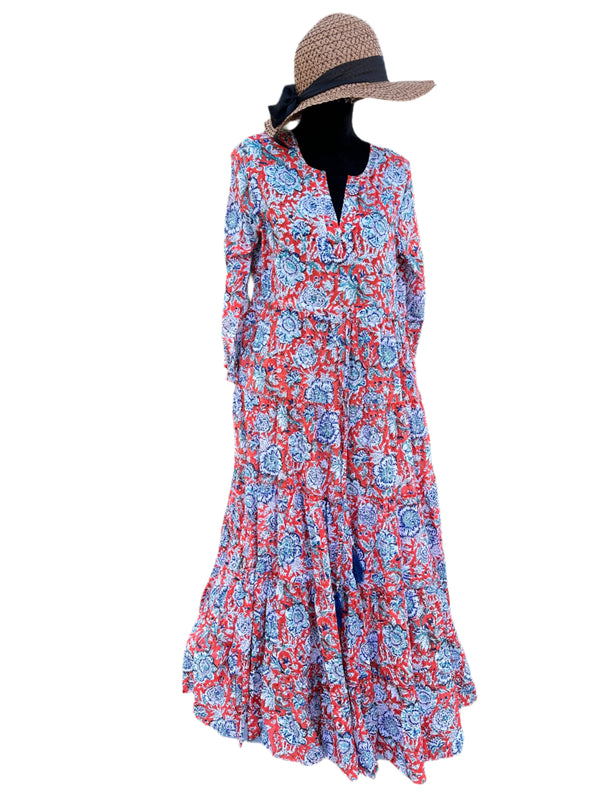 The dress in the image has a vibrant orange base color with blue, white, and purple floral patterns. The combination of these colors gives it a bold, lively, and eye-catching look, perfect for a bohemian or vintage-inspired style.
