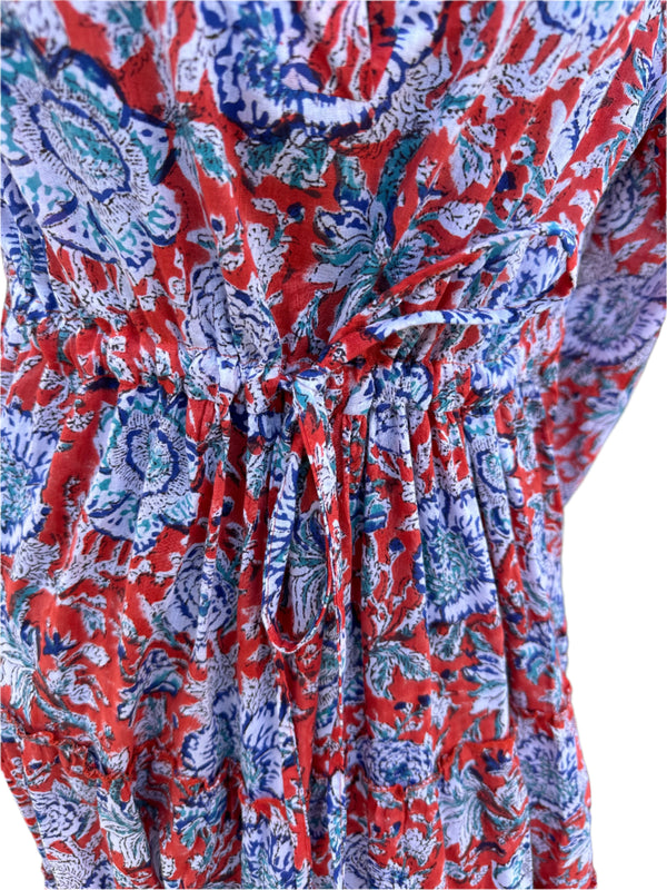 the image has a vibrant orange base color with blue, white, and purple floral patterns.