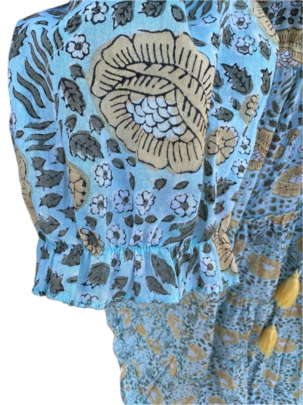The fabric in the image has a light blue -Green base color with floral and botanical patterns in beige, black, and white. The design  has a hand-block printed traditional textile look, with earthy tones complementing the blue background.Image shows a finished sleeve