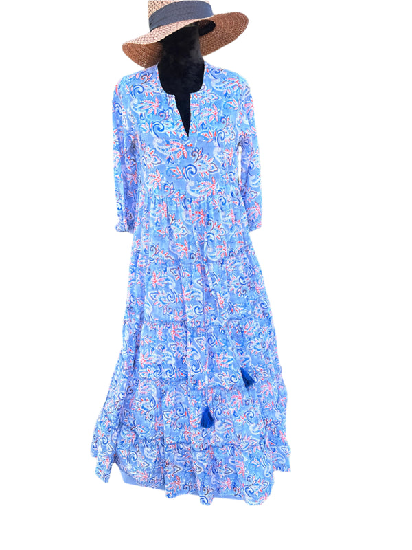 The dress in the image has a soft blue base color with orange, white, and navy blue paisley patterns. It also features blue tassel accents, adding a bohemian and elegant touch to the overall design.